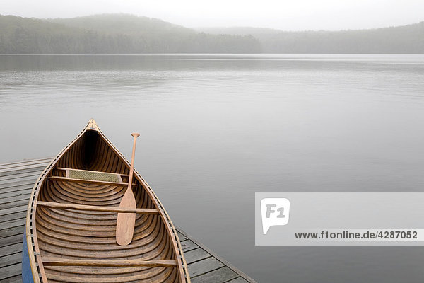 Canoe on cottage dock on a misty morning  Algonquin Park  Ontario