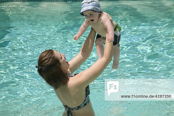 Mother lifting her baby boy up in a swimming pool  Ontario