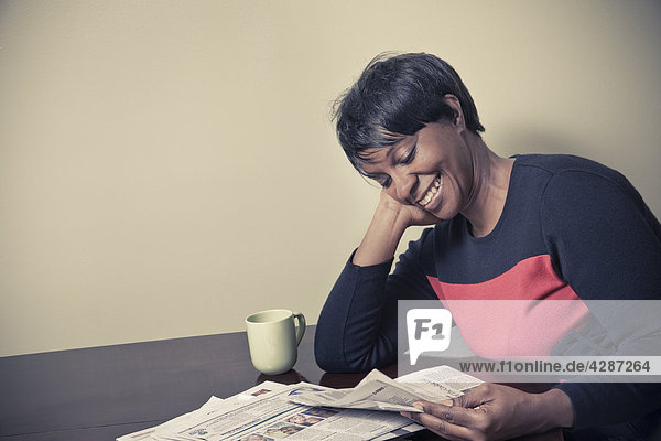 Schwarze Frau  Alter 44  eine Zeitung lesen