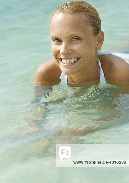 Frau im Wasser  lächelnd vor der Kamera