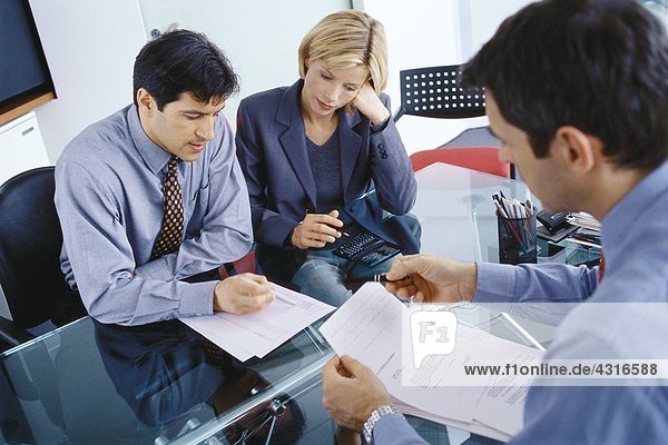 Professional couple having meeting with businessman  discussing documents