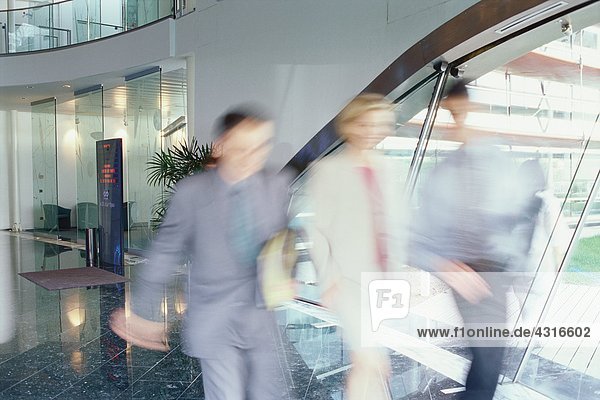 Business executives walking in lobby  blurred motion