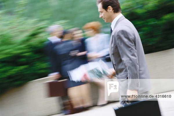 Businessman carrying bouquet of flowers and briefcase