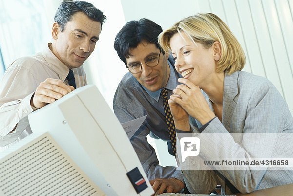 Geschäftsfreunde  die am Desktop-Computer arbeiten