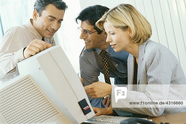 Geschäftsfreunde  die am Desktop-Computer arbeiten