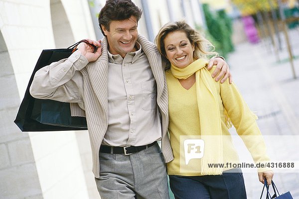 Mature couple walking with shopping bags