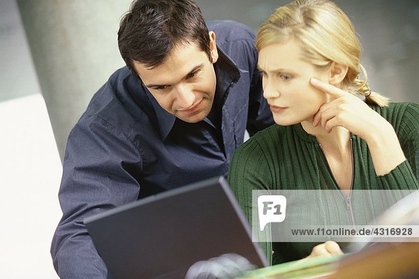 Man and woman using laptop