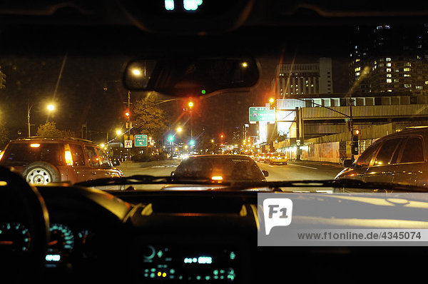 Überfüllte Stadtstraße bei Nacht vom Auto aus gesehen