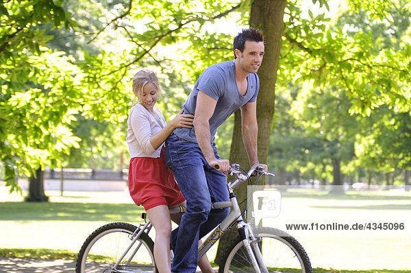 Young couple riding bicycle together
