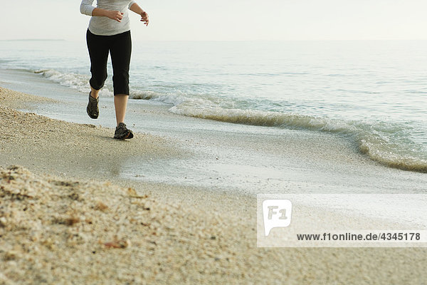 Woman jogging at the beach  low section