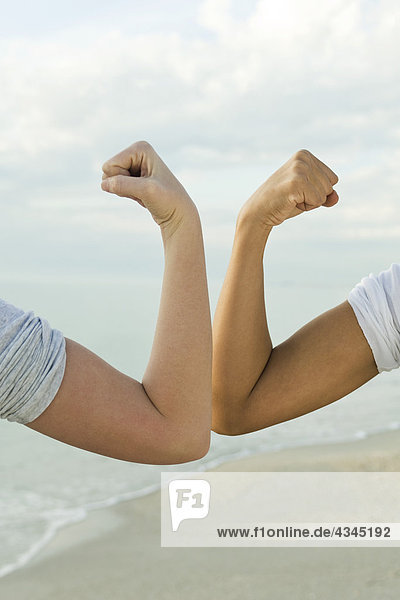 Women flexing arms  cropped
