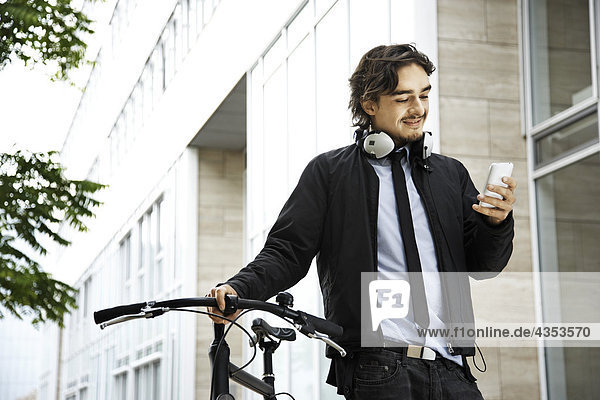 Mann neben dem Fahrrad  Kopfhörer auf