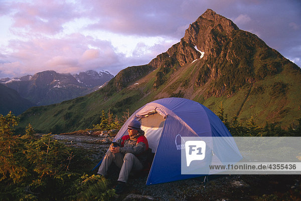 Man sitzt außerhalb Zelt @ Campingplatz in Abend Küste CT Southeast Alaska Sommer