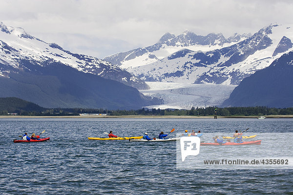 Sea kayakers in Gastineau Channel with Mendenhall Glacier and Coast Mountains in the background in Southeast Alaska during Summer