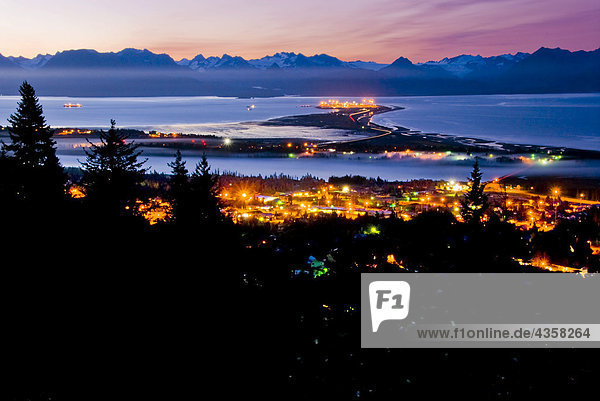 Early morning view of the Homer Spit as night gives way to the dawn over the Kenai Mountains and Kachemak Bay on the Kenai Peninsula of Southcentral Alaska