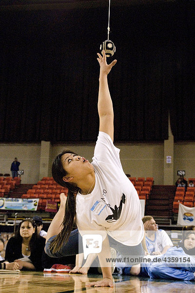 Girl doing One Hand Reach 2006 Senior Native Youth Olympic Games Alaska Anchorage Sullivan Arena