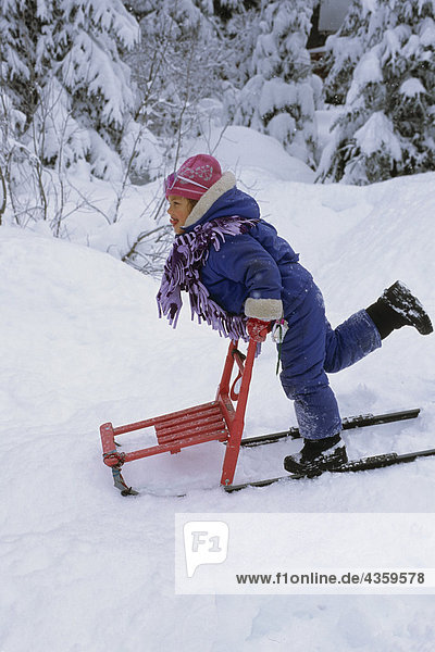 Young Girl Playing auf Tretschlitten im tiefen Schnee SC AK Winter