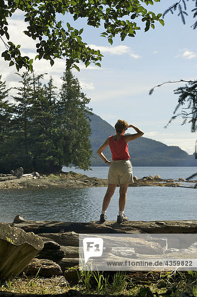 Woman enjoys scenic coastal view near Ketchikan during Summer in Southeast Alaska