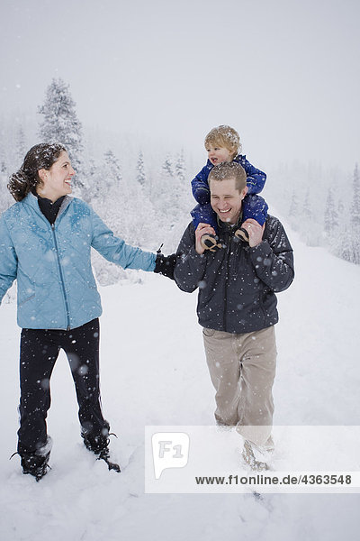Couple take young son for an outdoor walk during Winter in Pedro Bay  Alaska.