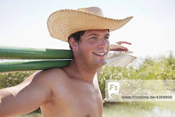 Man in straw hat looking across lake