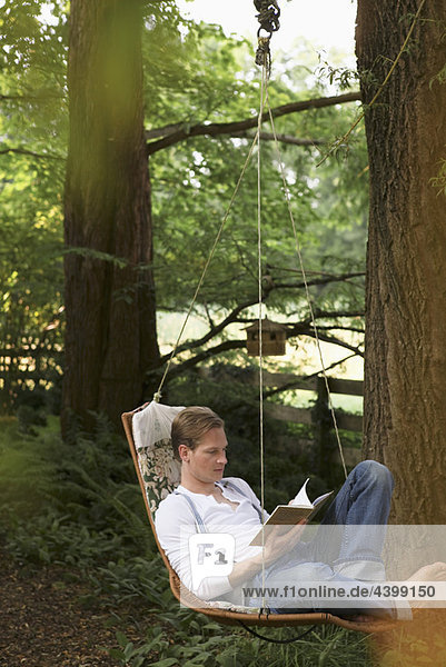 Young man reading in hammock