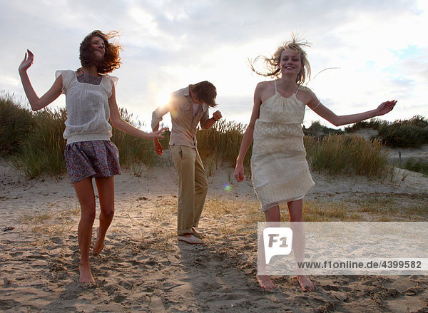 Friends dancing at the beach at sunset