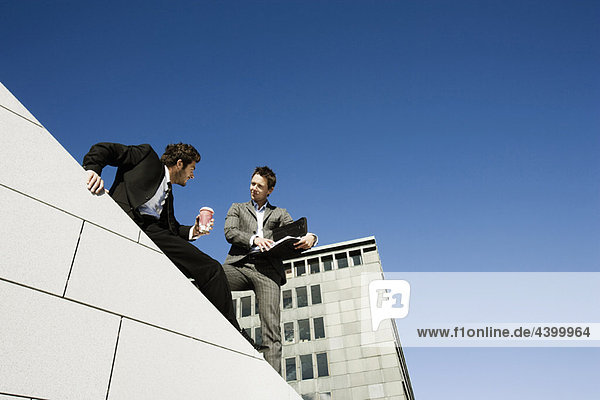 Männer machen Geschäfte auf dem Dach