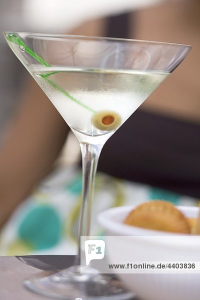 Martini mit grünen Olive  Cracker  Frau Hintergrund
