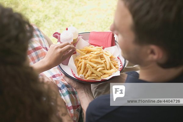 Couple eating chips in garden