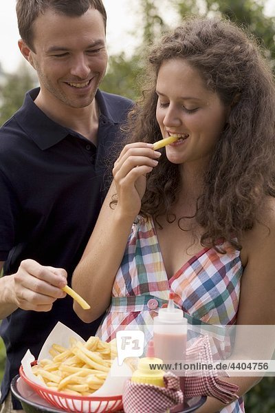 Couple eating chips at a barbecue