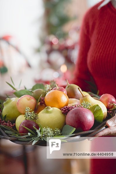 Frau hält Schüssel Früchte (Christmas)