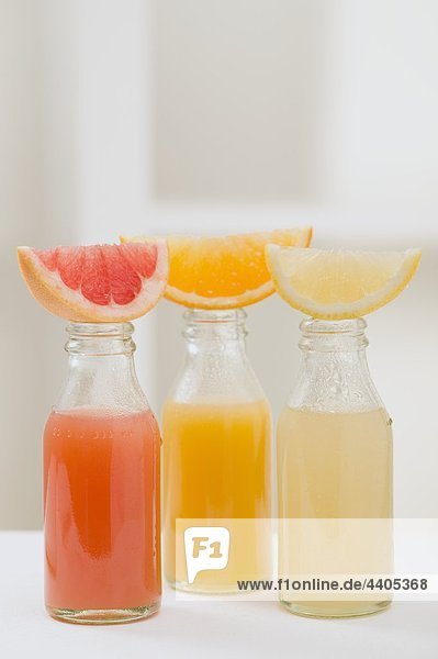 Drei Fruchtsäfte in Flaschen mit Keile mit Früchten