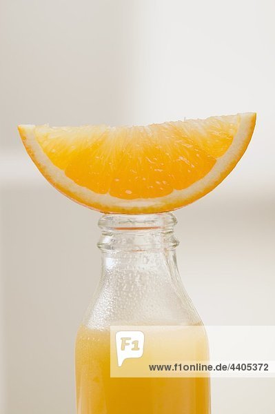 Orangensaft in Flasche mit frischem orange Keil