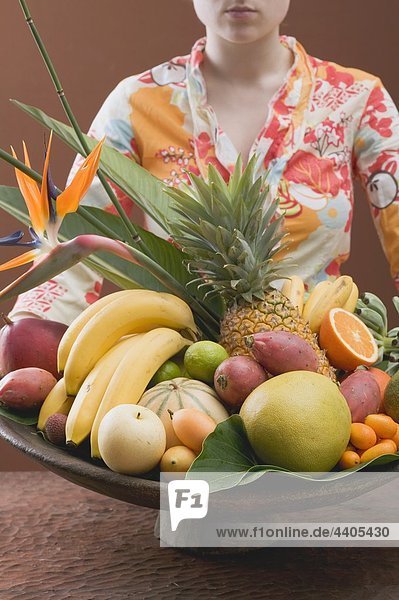 Frau hält Schüssel mit exotischen Früchten
