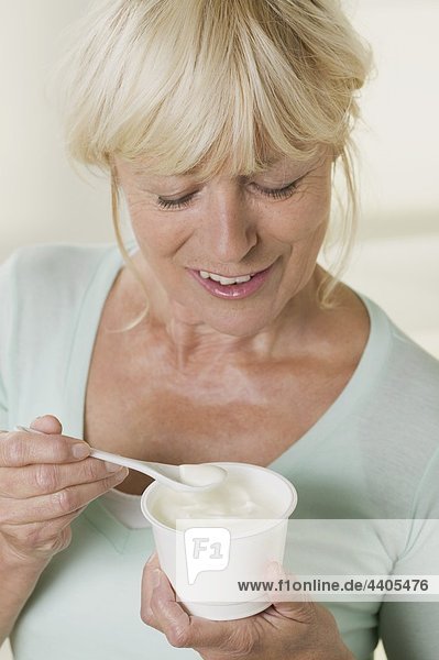 Frau Essen Joghurt aus der Kunststoff-Topf