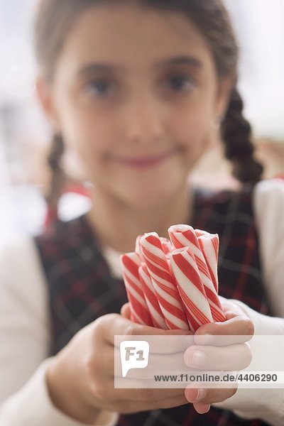Girl holding several candy sticks