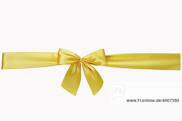 Yellow bow against white background  close-up