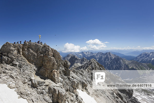Österreich Tirol Zugspitze Menschen und Kreuz auf Berggipfel
