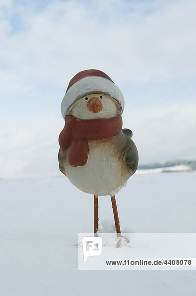 Clay duck with santa hat standing in snow  wnter.