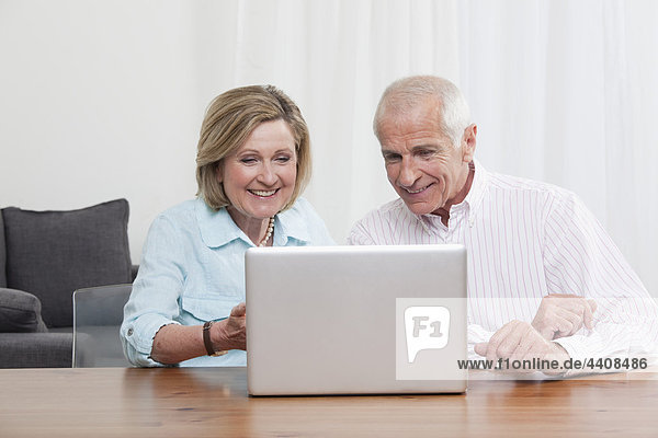 Senior couple using laptop  smiling