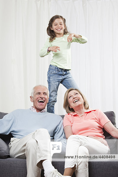 Granddaughter (6-7) dancing and grandparents enjoying  smiling