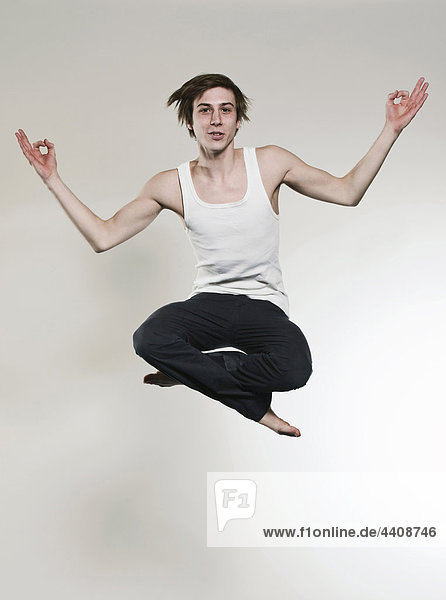 Mann springt mit gekreuzten Beinen und Gestik  Portrait