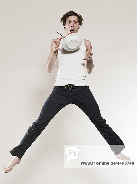 Man holding plate and jumping  portrait