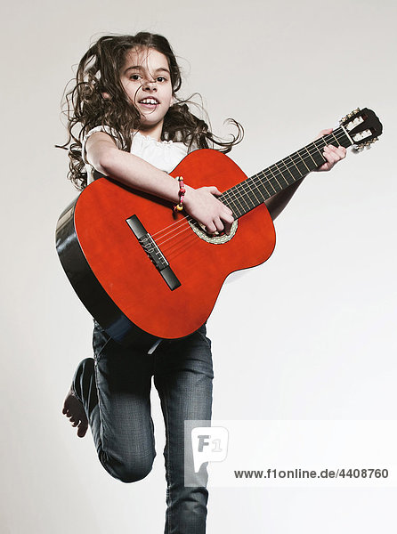Girl (12-13) playing guitar  smiling