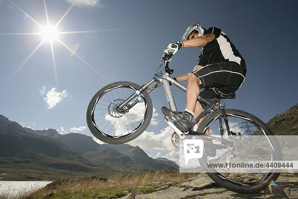Switzerland  Tessin  Man doing stunt on mountain bike