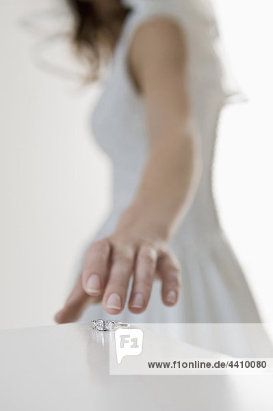 Mittelteil der Braut beim Verlassen des Eherings auf dem Tisch