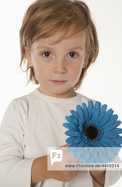 Junge (4-5) mit blauer Blume  Portrait  Nahaufnahme