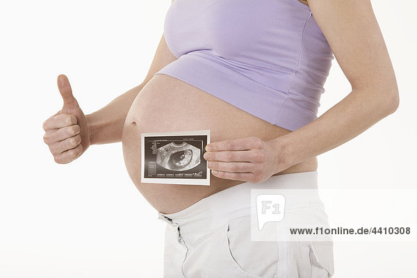 Schwangere Frau mit Sonogrammbild  mit Daumen nach oben  Mittelteil