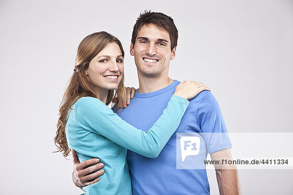 Man embracing woman  smiling  portrait
