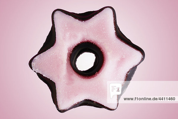 Sternförmiges Chritmas-Cookie auf rosa Hintergrund